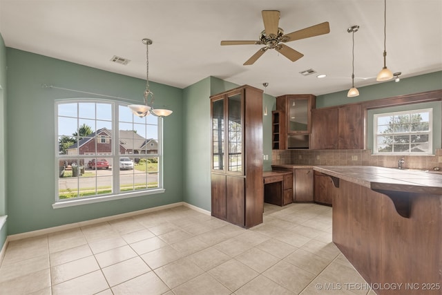 108 W 135th St, Skiatook, OK 74070 - kitchen with light tile patterned flooring, decorative backsplash, glass insert cabinets, ceiling fan, and pendant lighting
