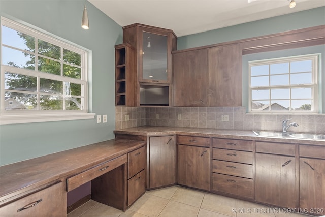 108 W 135th St, Skiatook, OK 74070 - kitchen with light tile patterned floors, decorative backsplash, healthy amount of natural light, and glass insert cabinets