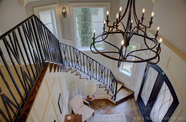 4401 S Yellow Pine Ave, Broken Arrow, OK 74011 - stairway with plenty of natural light, a decorative wall, a towering ceiling, and a chandelier