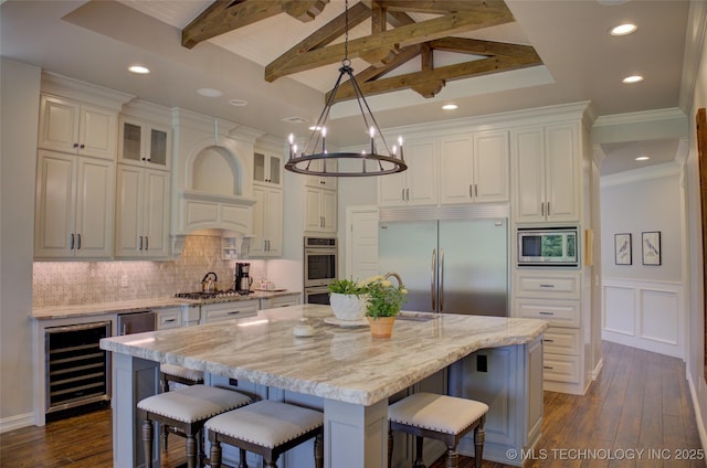 4401 S Yellow Pine Ave, Broken Arrow, OK 74011 - kitchen featuring built in appliances, beverage cooler, white cabinetry, dark wood-type flooring, and a kitchen breakfast bar