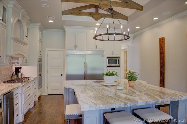 4401 S Yellow Pine Ave, Broken Arrow, OK 74011 - kitchen featuring built in appliances, wine cooler, a breakfast bar area, beam ceiling, and light stone counters