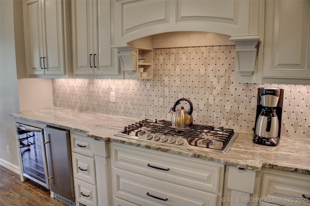 4401 S Yellow Pine Ave, Broken Arrow, OK 74011 - kitchen with wine cooler, stainless steel gas stovetop, tasteful backsplash, dark wood-style flooring, and light stone counters