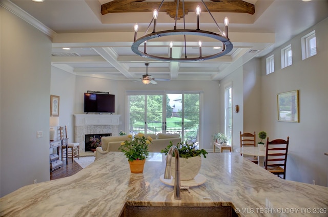 4401 S Yellow Pine Ave, Broken Arrow, OK 74011 - dining space featuring a chandelier, beamed ceiling, coffered ceiling, a tiled fireplace, and a ceiling fan