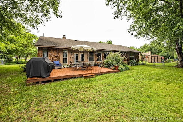 9601 Spring Lake Dr, Broken Arrow, OK 74014 - rear view of house featuring a fenced backyard, a deck, a chimney, stone siding, and a storage shed