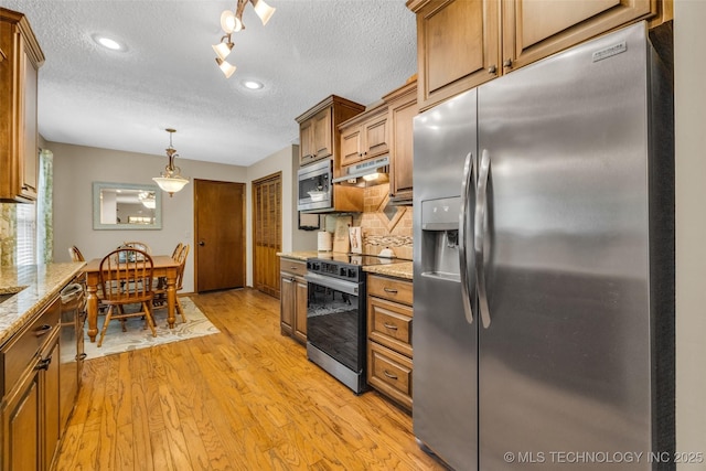 9601 Spring Lake Dr, Broken Arrow, OK 74014 - kitchen featuring appliances with stainless steel finishes, a textured ceiling, light wood finished floors, under cabinet range hood, and brown cabinetry