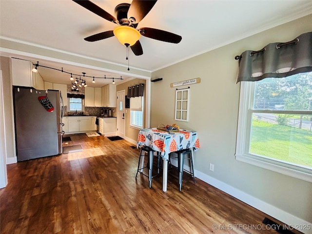 401 High St, Eufaula, OK 74432 - dining area featuring dark wood-style flooring, a ceiling fan, crown molding, and rail lighting