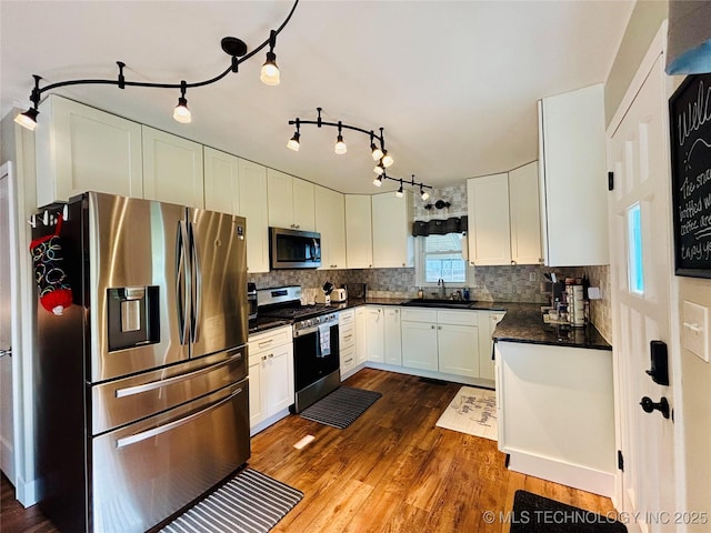 401 High St, Eufaula, OK 74432 - kitchen with appliances with stainless steel finishes, dark countertops, white cabinets, and tasteful backsplash