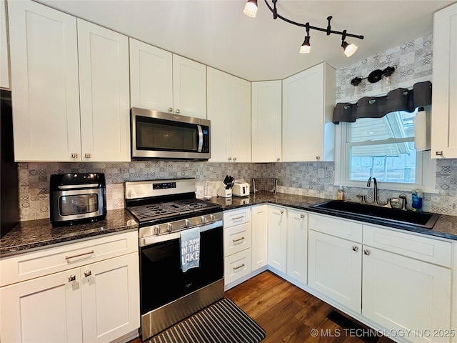 401 High St, Eufaula, OK 74432 - kitchen featuring appliances with stainless steel finishes, white cabinetry, dark wood-style flooring, backsplash, and dark stone countertops