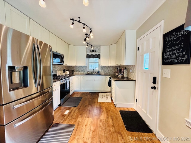 401 High St, Eufaula, OK 74432 - kitchen featuring stainless steel appliances, dark countertops, light wood-style flooring, and white cabinets
