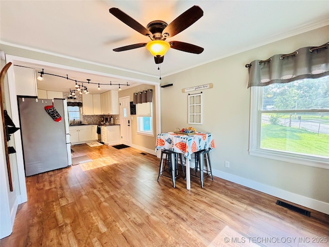 401 High St, Eufaula, OK 74432 - dining area featuring light wood-style flooring, plenty of natural light, and ornamental molding