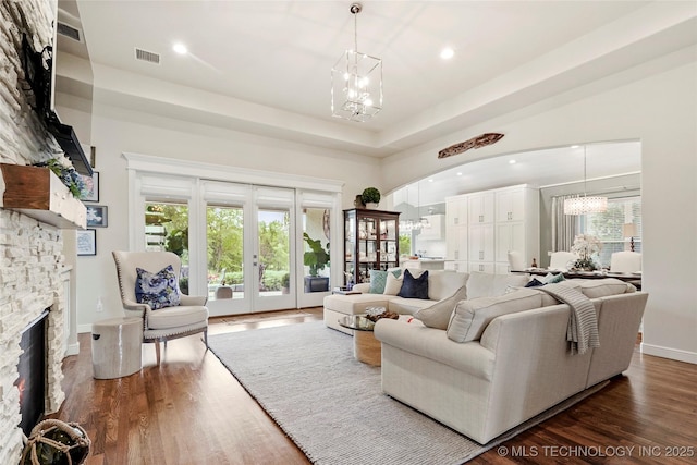 8701 E Hartford St, Broken Arrow, OK 74014 - living room with a chandelier, dark wood-style flooring, recessed lighting, a fireplace, and arched walkways