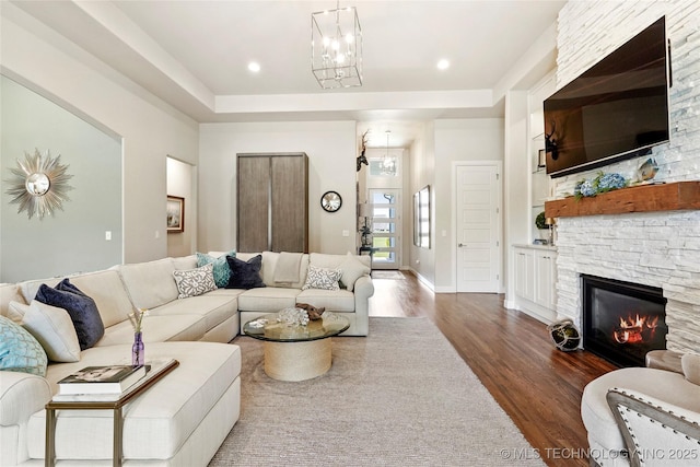 8701 E Hartford St, Broken Arrow, OK 74014 - living area featuring dark wood-style flooring, a chandelier, a fireplace, and a tray ceiling