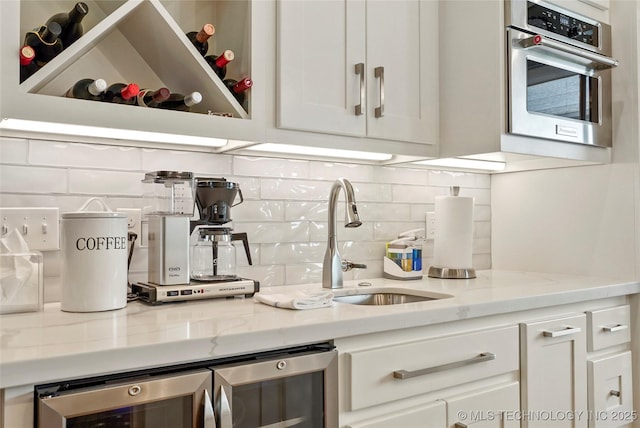 8701 E Hartford St, Broken Arrow, OK 74014 - kitchen featuring stainless steel oven, tasteful backsplash, white cabinetry, light stone counters, and beverage cooler