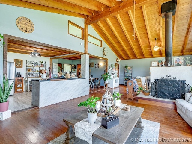 10696 N County Road 3410, Stratford, OK 74872 - living room with a wooden ceiling with exposed beams, hardwood / wood-style flooring, high vaulted ceiling, and a wood stove