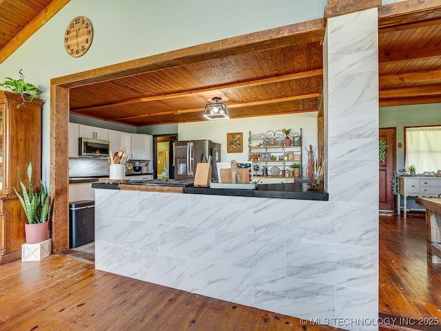10696 N County Road 3410, Stratford, OK 74872 - kitchen with a wood ceiling with exposed beams, appliances with stainless steel finishes, white cabinets, hardwood / wood-style flooring, and a peninsula