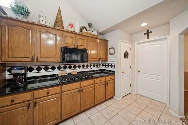 13605 E 90th Ct, Owasso, OK 74055 - kitchen with black microwave, gas cooktop, tasteful backsplash, brown cabinets, and light tile patterned floors