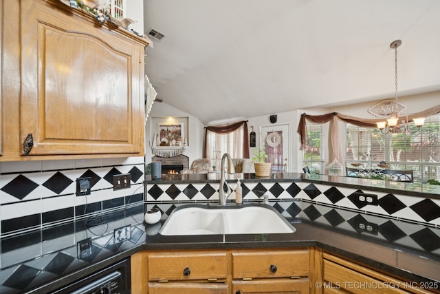 13605 E 90th Ct, Owasso, OK 74055 - kitchen featuring dark countertops, lofted ceiling, tasteful backsplash, a lit fireplace, and decorative light fixtures