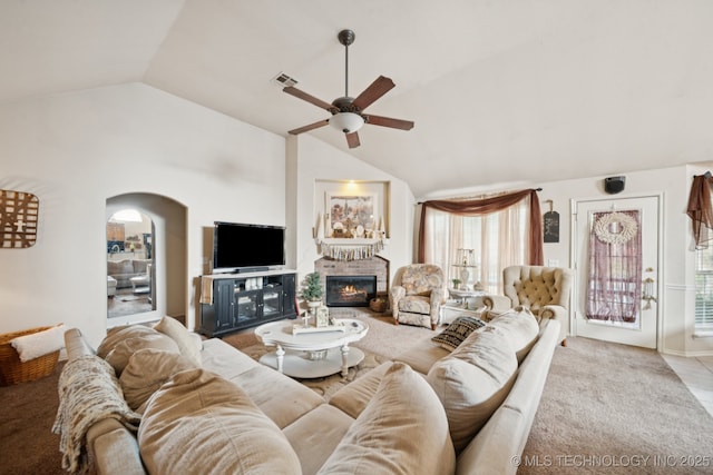 13605 E 90th Ct, Owasso, OK 74055 - carpeted living area with lofted ceiling, ceiling fan, a fireplace, and arched walkways
