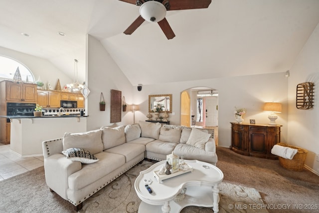 13605 E 90th Ct, Owasso, OK 74055 - living area featuring ceiling fan, arched walkways, lofted ceiling, plenty of natural light, and light colored carpet