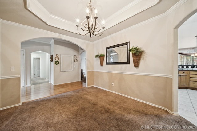 13605 E 90th Ct, Owasso, OK 74055 - unfurnished dining area with a chandelier, arched walkways, carpet, a raised ceiling, and crown molding