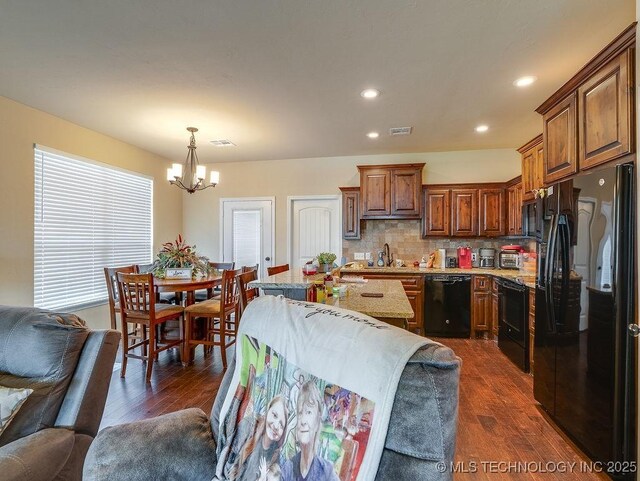 1125 Emily Ln, Ada, OK 74820 - kitchen with black appliances, open floor plan, a chandelier, dark wood-style flooring, and light stone countertops