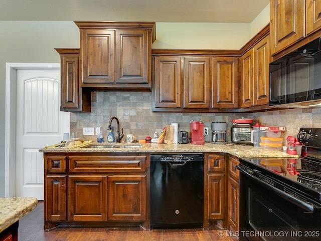 1125 Emily Ln, Ada, OK 74820 - kitchen with black appliances, tasteful backsplash, and light stone counters