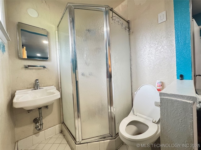 9763 E 3rd St, Tulsa, OK 74128 - bathroom with a stall shower, tile patterned floors, and a textured wall