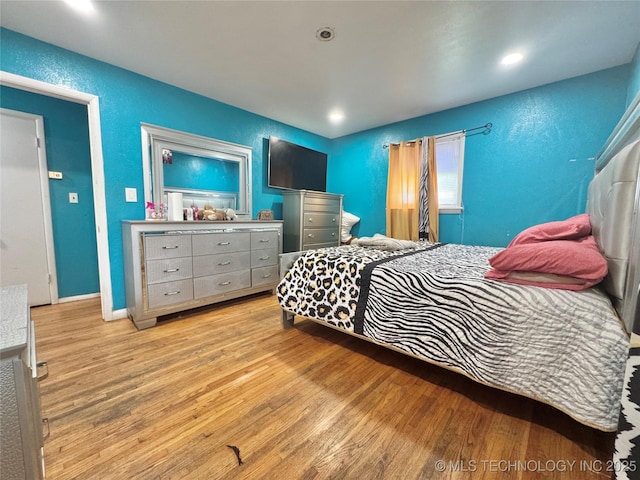 9763 E 3rd St, Tulsa, OK 74128 - bedroom featuring wood finished floors, a textured wall, and recessed lighting