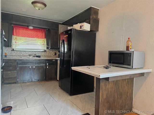 9763 E 3rd St, Tulsa, OK 74128 - kitchen with stainless steel microwave, freestanding refrigerator, light countertops, decorative backsplash, and a peninsula