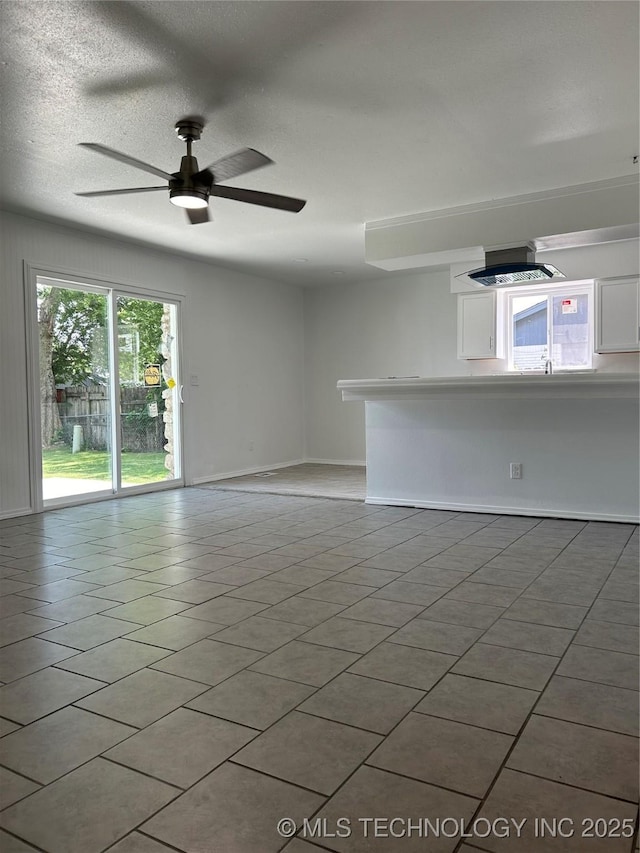 12976 E 32nd St, Tulsa, OK 74134 - unfurnished living room with a ceiling fan, a textured ceiling, and light tile patterned flooring