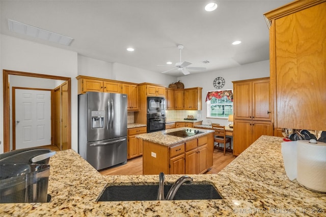 4556 E 330th Rd, Talala, OK 74080 - kitchen featuring black appliances, light stone counters, ceiling fan, a center island, and light wood-type flooring