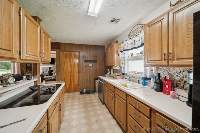 1222 N Cherrington Ave, Claremore, OK 74017 - kitchen featuring light flooring, dishwasher, light countertops, tasteful backsplash, and wood walls