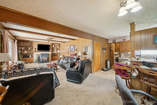 1222 N Cherrington Ave, Claremore, OK 74017 - living room with a textured ceiling, washer / clothes dryer, carpet floors, wooden walls, and beamed ceiling