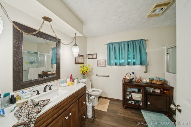 1222 N Cherrington Ave, Claremore, OK 74017 - bathroom featuring vanity, a shower stall, wood finished floors, and a textured ceiling