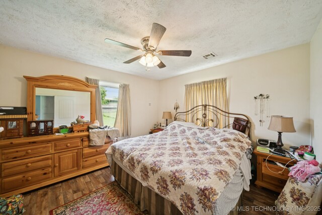 1222 N Cherrington Ave, Claremore, OK 74017 - bedroom featuring dark wood-type flooring, a textured ceiling, and ceiling fan