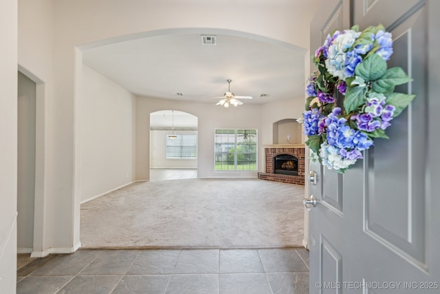 513 S 63rd Pl S, Broken Arrow, OK 74014 - entrance foyer featuring carpet, ceiling fan, a brick fireplace, and arched walkways