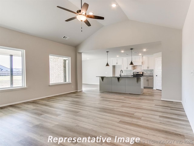 7218 E 132nd St S, Bixby, OK 74008 - unfurnished living room featuring ceiling fan, high vaulted ceiling, light wood-style flooring, and recessed lighting