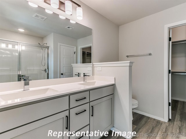 7218 E 132nd St S, Bixby, OK 74008 - full bathroom featuring wood finished floors, a walk in closet, a shower stall, and double vanity
