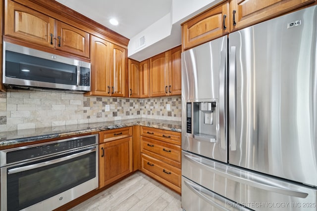 6002 S Atlanta Ct Unit 2, Tulsa, OK 74105 - kitchen with stainless steel appliances, light stone counters, brown cabinets, and recessed lighting