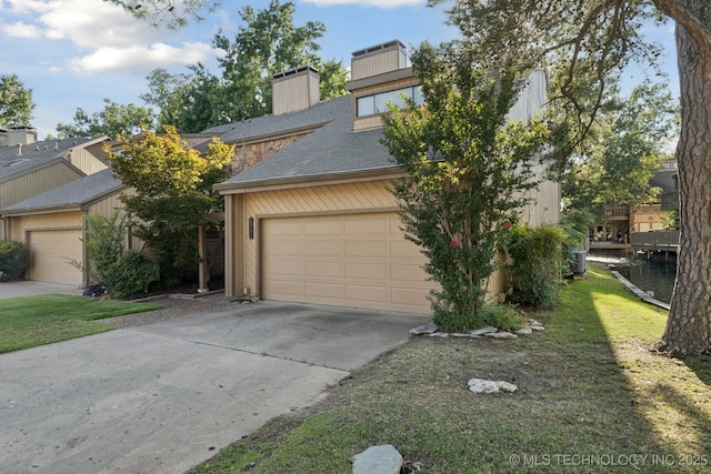 6002 S Atlanta Ct Unit 2, Tulsa, OK 74105 - view of front facade with concrete driveway, roof with shingles, a chimney, and a garage