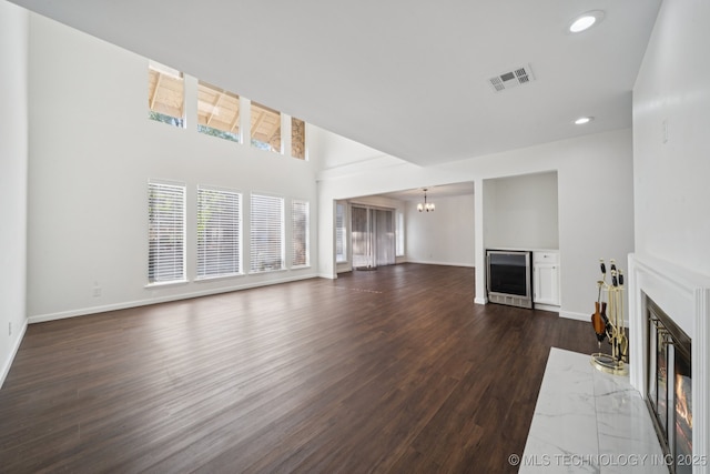 6002 S Atlanta Ct Unit 2, Tulsa, OK 74105 - unfurnished living room featuring a premium fireplace, a chandelier, dark wood finished floors, recessed lighting, and wine cooler