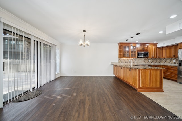 6002 S Atlanta Ct Unit 2, Tulsa, OK 74105 - kitchen with appliances with stainless steel finishes, a peninsula, brown cabinetry, wood finished floors, and a chandelier