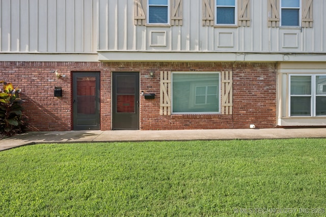 6152 S Madison Pl Unit B, Tulsa, OK 74136 - entrance to property featuring brick siding, a yard, and board and batten siding