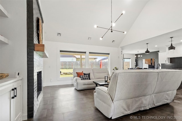 2035 E 138th Pl S, Bixby, OK 74008 - living room featuring a chandelier, high vaulted ceiling, and a brick fireplace