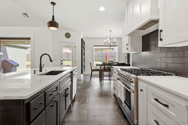 2035 E 138th Pl S, Bixby, OK 74008 - kitchen with stainless steel appliances, custom exhaust hood, white cabinetry, tasteful backsplash, and a chandelier