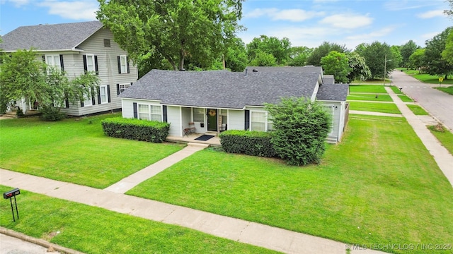925 W Cedar St N, Durant, OK 74701 - view of front of home with a front lawn, a shingled roof, and covered porch