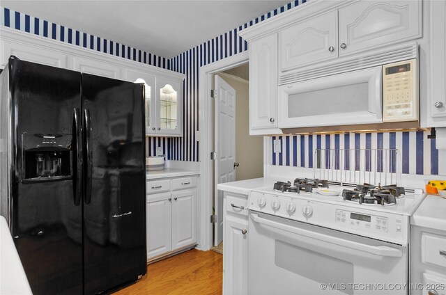 925 W Cedar St N, Durant, OK 74701 - kitchen with white appliances, wallpapered walls, light countertops, and white cabinetry