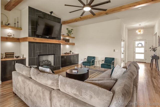 2407 W Union Pl, Collinsville, OK 74021 - living area with beamed ceiling, light wood-type flooring, a ceiling fan, and a tiled fireplace