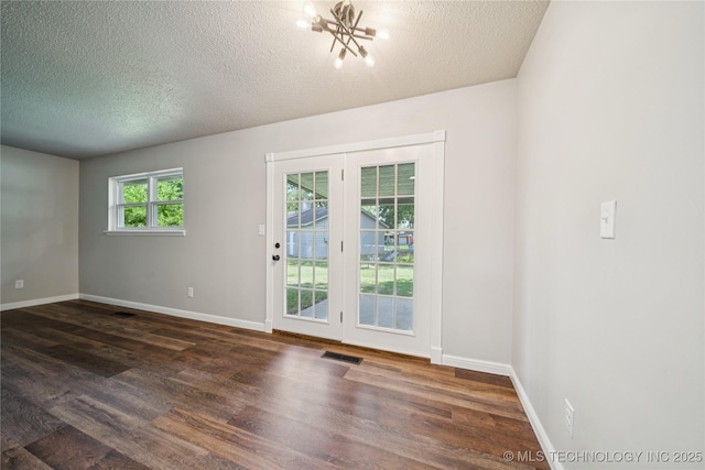 16524 E 2nd St, Tulsa, OK 74108 - unfurnished room featuring a textured ceiling, dark wood-style floors, and a chandelier