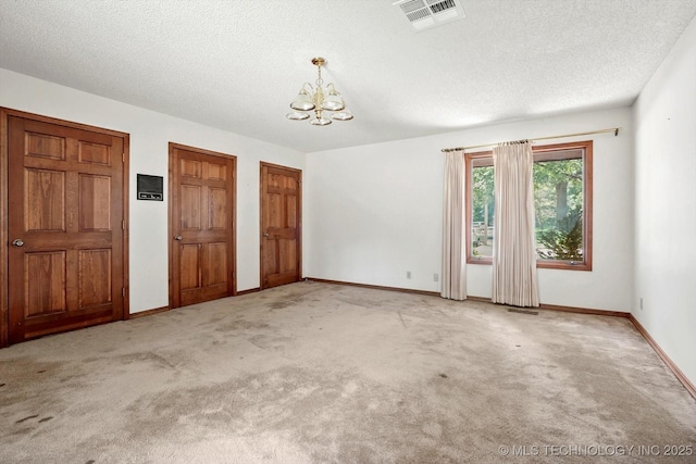 2425 E 53rd St, Tulsa, OK 74105 - spare room with a chandelier, a textured ceiling, and carpet flooring
